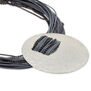 A silver hammered disc necklace pendant hosted by a grey cord. 